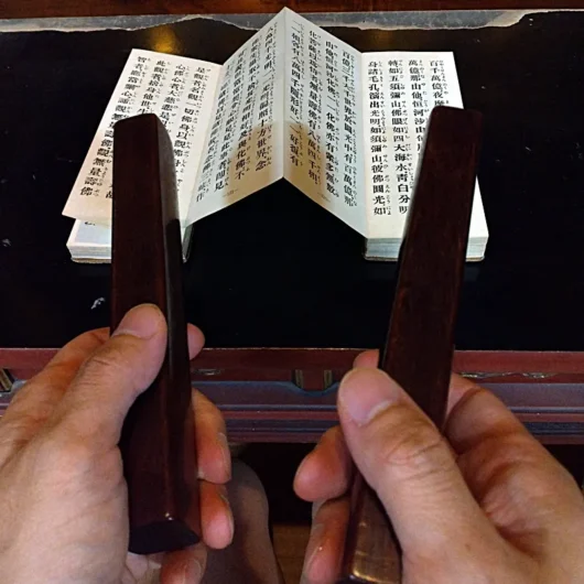 お経を読みながら音木を鳴らしている写真